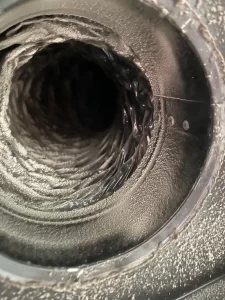 Close-up view of an air duct showing a buildup of dust and debris along the walls of the duct- Space Air Duct Cleaning
