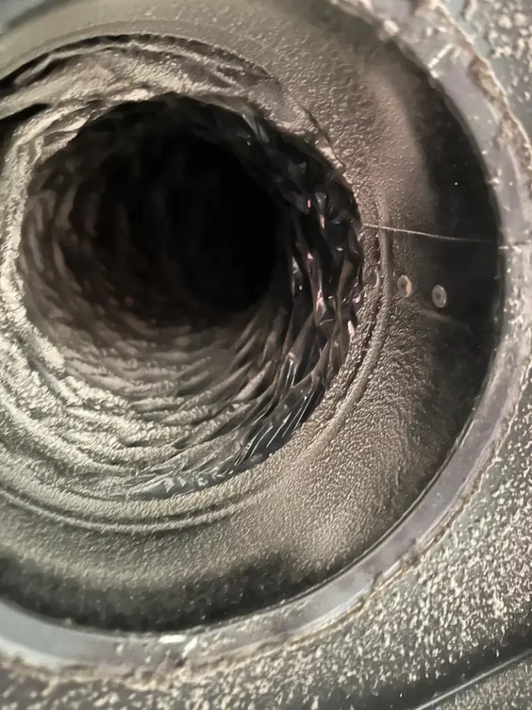 Close-up view of an air duct showing a buildup of dust and debris along the walls of the duct- Space Air Duct Cleaning