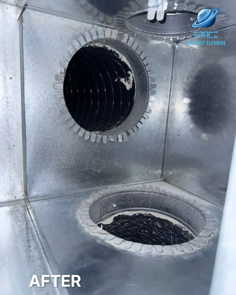 The clean interior of a metal air distribution box with two duct ports visible in a residential system.