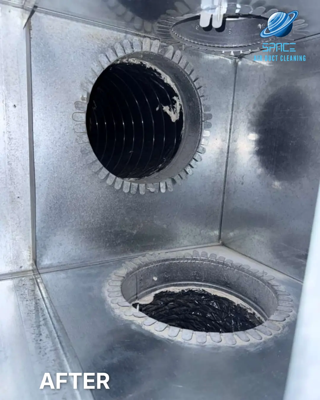 The clean interior of a metal air distribution box with two duct ports visible in a residential system.